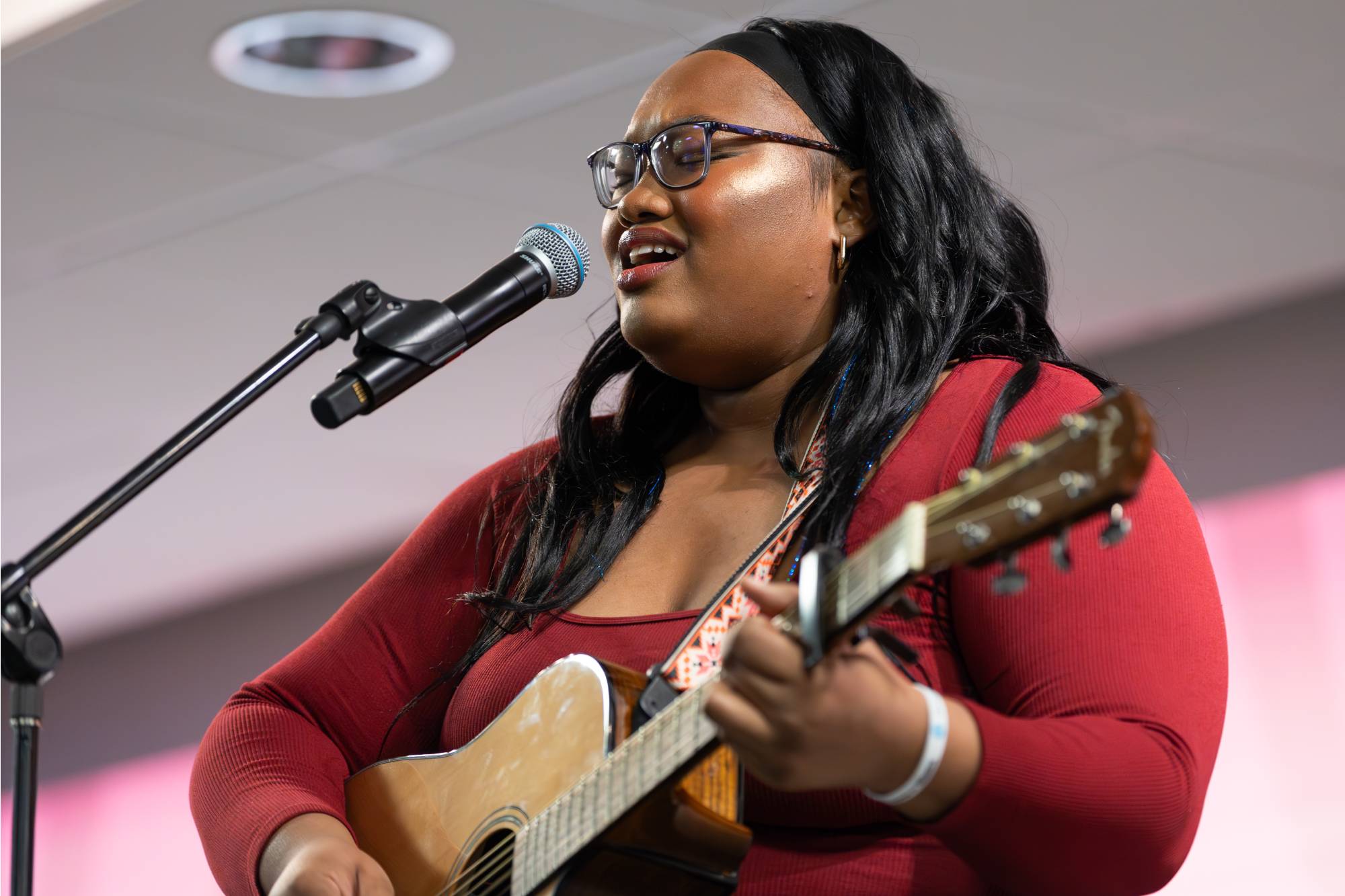 Reete Thorns playing guitar and singing into a microphone